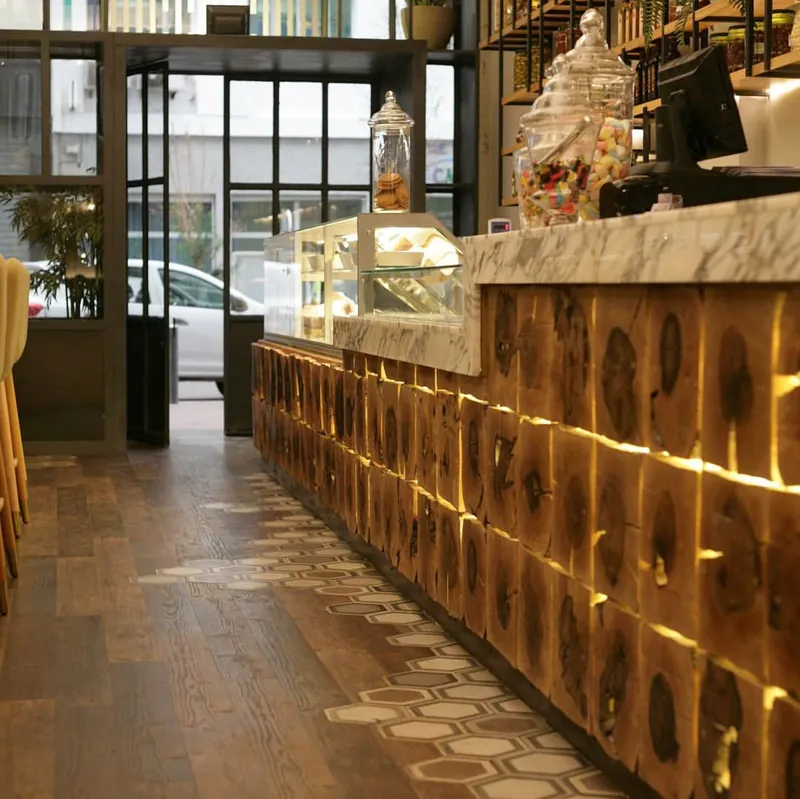 Comptoir du restaurant en rondins de bois éclairés, vitrine traiteur, sol en bois