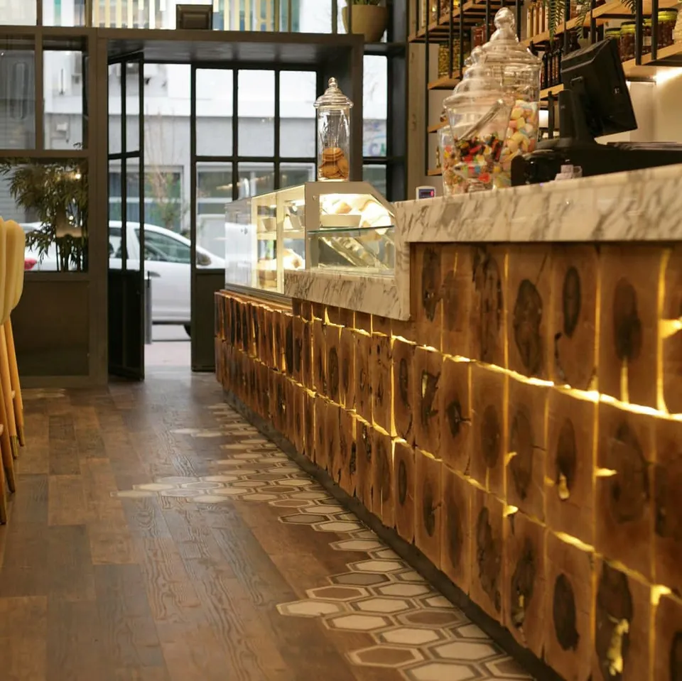 Comptoir du restaurant en rondins de bois éclairés, vitrine traiteur, sol en bois