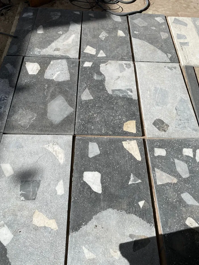 Échantillons de terrazzo noir aux éclats de marbre posés côte à côte