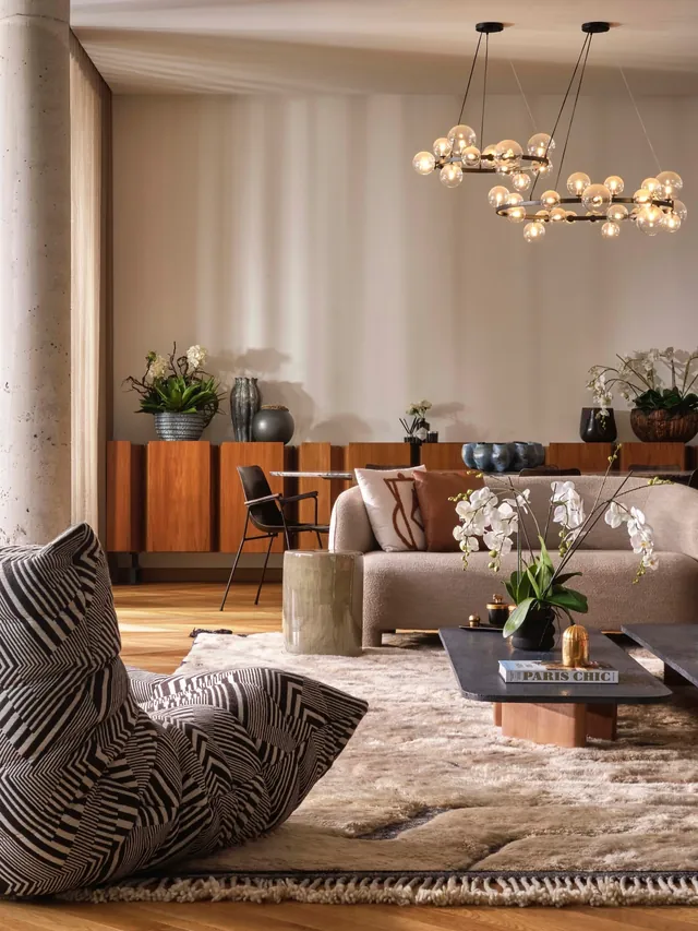 Coin salon : fauteuil zébré, canapé clair, enfilade en bois, orchidées